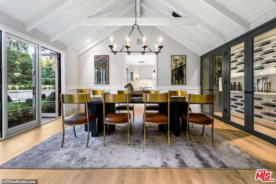 Dining: Just off the grand room is a dining room, against set beside large french doors, and beneath vaulted white wood ceilings. A large wine room is built into the entire wall in the dining room opposite the doors leading outside