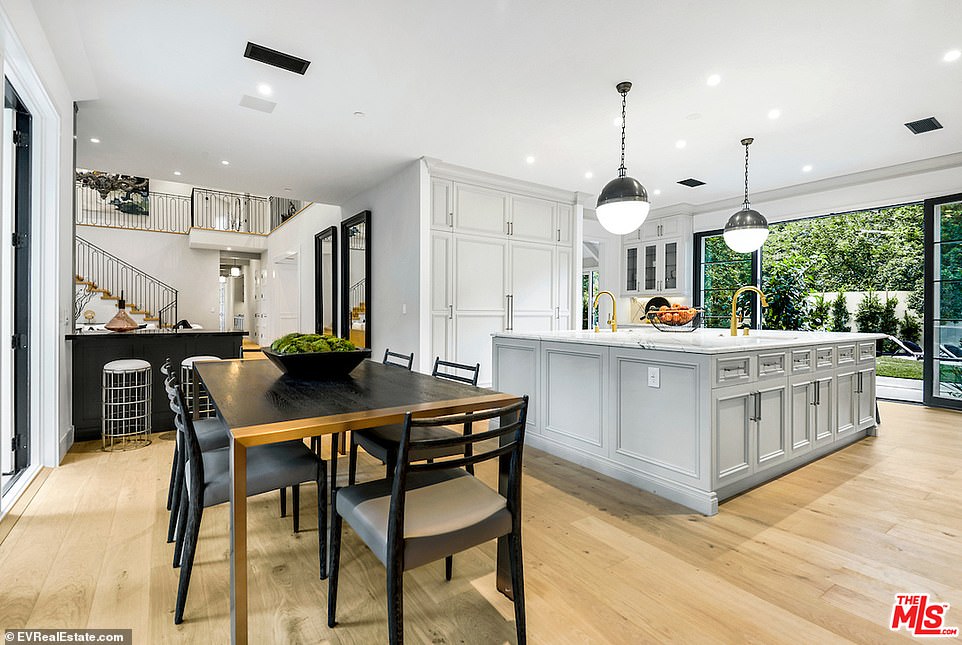 Built in: The fridge is seamlessly built into the kitchen, matching the light grey cabinets, with black metal hardware
