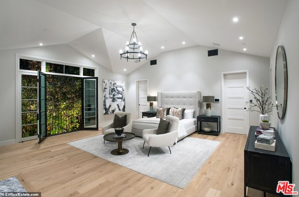 Modern: A modern bedroom upstairs gets recessed lighting and a two-tiered chandelier